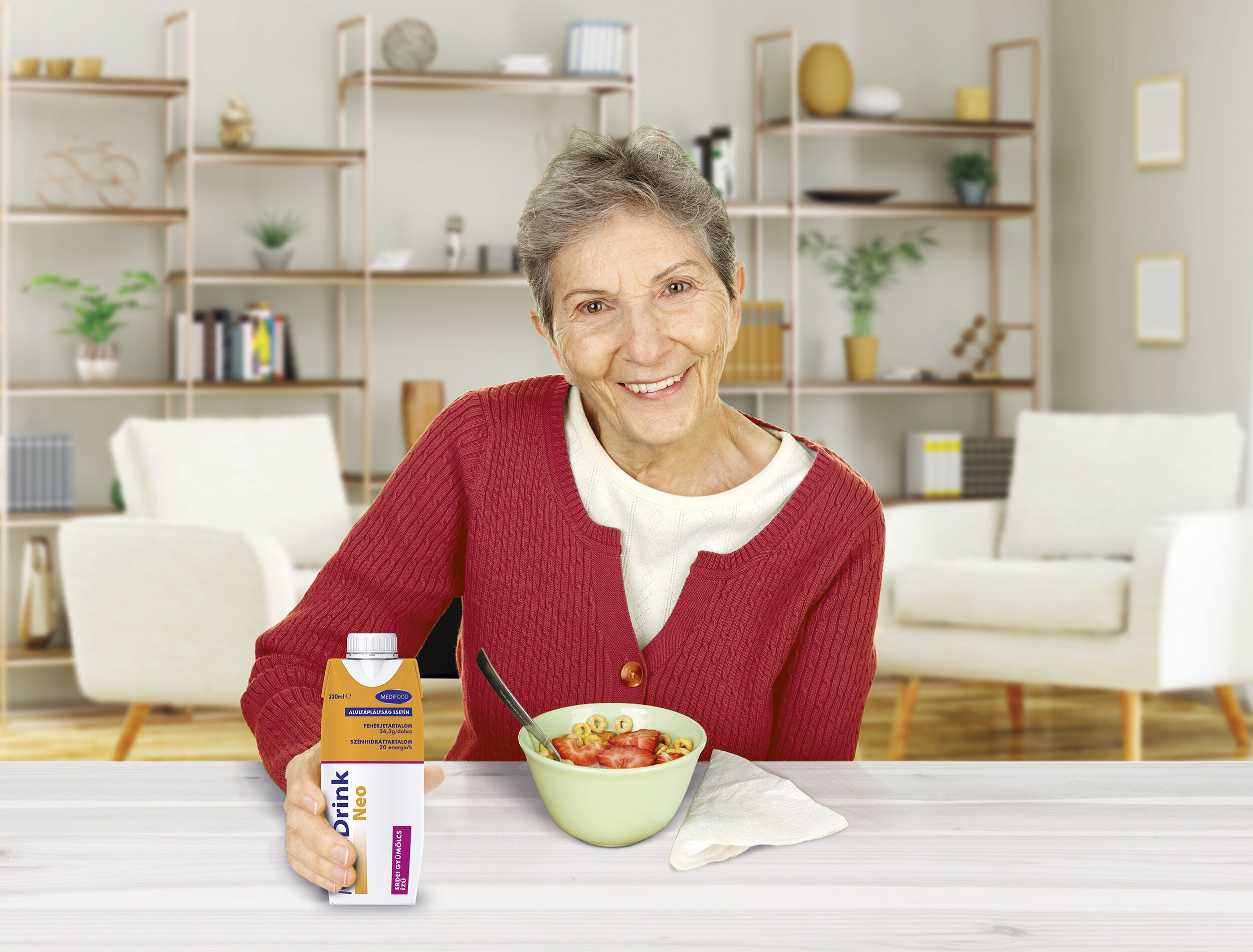 A senior woman enjoying a breakfast of cereal with strawberries and orange juice.